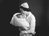 Nurse Hugging Newborn (0-3 Months) Wrapped in Blanket