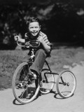 Young Boy (6-7) Riding Tricycle in Park  Portrait