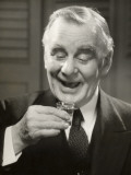 Elderly Man Raising Glass of Whiskey