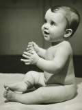 Baby Boy (12-18 Months) With Raised Hands  Sitting on Bedspread