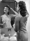 Woman Fixing Hair in Mirror