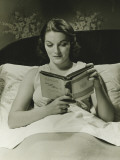 Woman Reading Book in Bed