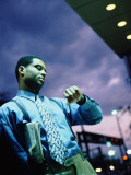 Man Standing Outside at Night  Looking at Wristwatch