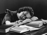 Female College Student Asleep on Open Books at Her Desk