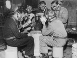 Group of Men Playing Cards  Wearing Gas Masks
