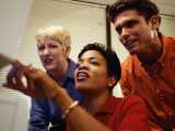 One Man and Two Women Looking at Computer Screen