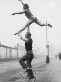 Male Acrobat on Unicycle Supporting Woman in Air