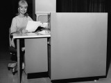 Woman Holding Paper and Sitting at Desk