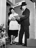 Woman Listening To Salesman in Doorway