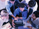 Group of People Gathered Around Laptop Computer  Overhead View