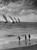 Three Boys Running Along Beach  Following Four Sailboats Out on Ocean