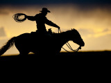 A Silhouetted Cowboy Riding Alone a Ridge at Sunset in Shell  Wyoming  USA