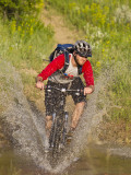 Mountain Biker Splashes Through Andrews Creek  Maah Daah Hey Trail in Medora  North Dakota  USA
