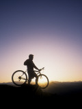Silhouette of Mountain Biker at the Summit During Sunrise