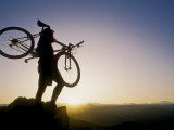 Silhouette of Mountain Biker at the Summit During Sunrise
