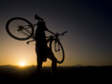 Silhouette of Mountain Biker at the Summit During Sunrise