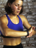 Young Woman Exercising on a Stationary Bike Checking her Heart Rate