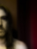 Portrait of Long Haird Man in Front of Curtains
