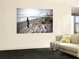 Woman Standing on Driftwood and Looking Towards Discovery Park Lighthouse