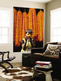 Little Girl Showing Off Marigold That She Stole from Beautiful Strings of Flowers