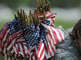 An Army Soldier's Backpack Overflows with Small American Flags