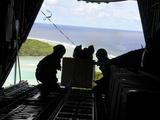 Airmen Push Out a Pallet of Donated Goods from a C-130 Hercules
