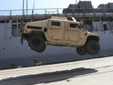 A Crane Lifts an M998 Humvee on the Flight Deck of USS Carter Hall