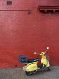 A Yellow Motor Scooter Against a Red Wall in Little Five Points