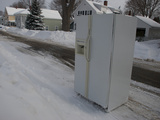 An Old Refrigerator at the Curb Waiting to Be Towed Away