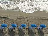 Umbrellas on a Beach with Approaching Surf at Sunrise
