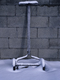 An Old Lawnmower Covered in Snow Against a Cinderblock Wall