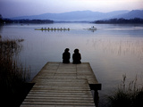 A Crew Boat and Women Sitting on a Dock on Lake Banyoles