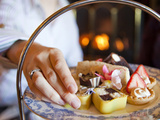 A Woman Reaches for a Dessert at a Restaurant