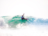 A Surfer Exits the Barrel over a Shallow Reef in Indonesia