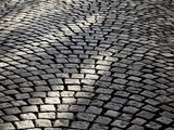 Patterns of Sunlight and Shadow on a Cobbled Road