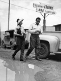 A Man and Woman Dodge a Puddle in the Street