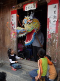 A Dragon Emerges from a Dragon Maker's Shop to Scare Children