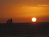 A Boat Sails across the Horizon at Sunset