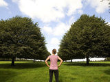 Young Woman Standing Among Small-Leaved Lime Trees  Tilia Cordata