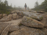 A Girl Hiking across Large Boulders in Early Morning Fog