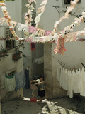 Woman Hangs Laundry in Alley Below Billowing St Anthony Streamers