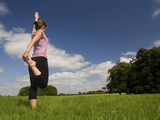 Young Woman Practicing Yoga in a Field