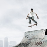 Young male skateboarder in mid air above a ramp