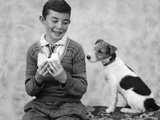 1920s 1930s Boy Eating Sandwich As Dog Stares At Food