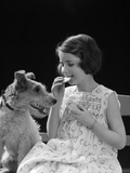 1920s 1930s Girl Eating Cookie With Dog