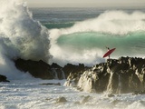 Surf Crashing near Surfer on Boulders