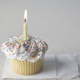 Cupcake with one candle and napkin