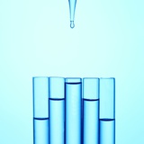 A Glass Pipette Drops Water in to a Series of Staggered Test Tubes or Vials