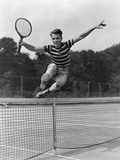 1930s Teenage Boy Tennis Player Jumping Net With Racket In Hand