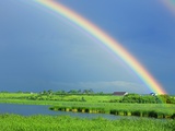 Double rainbow over lake and rural landscape